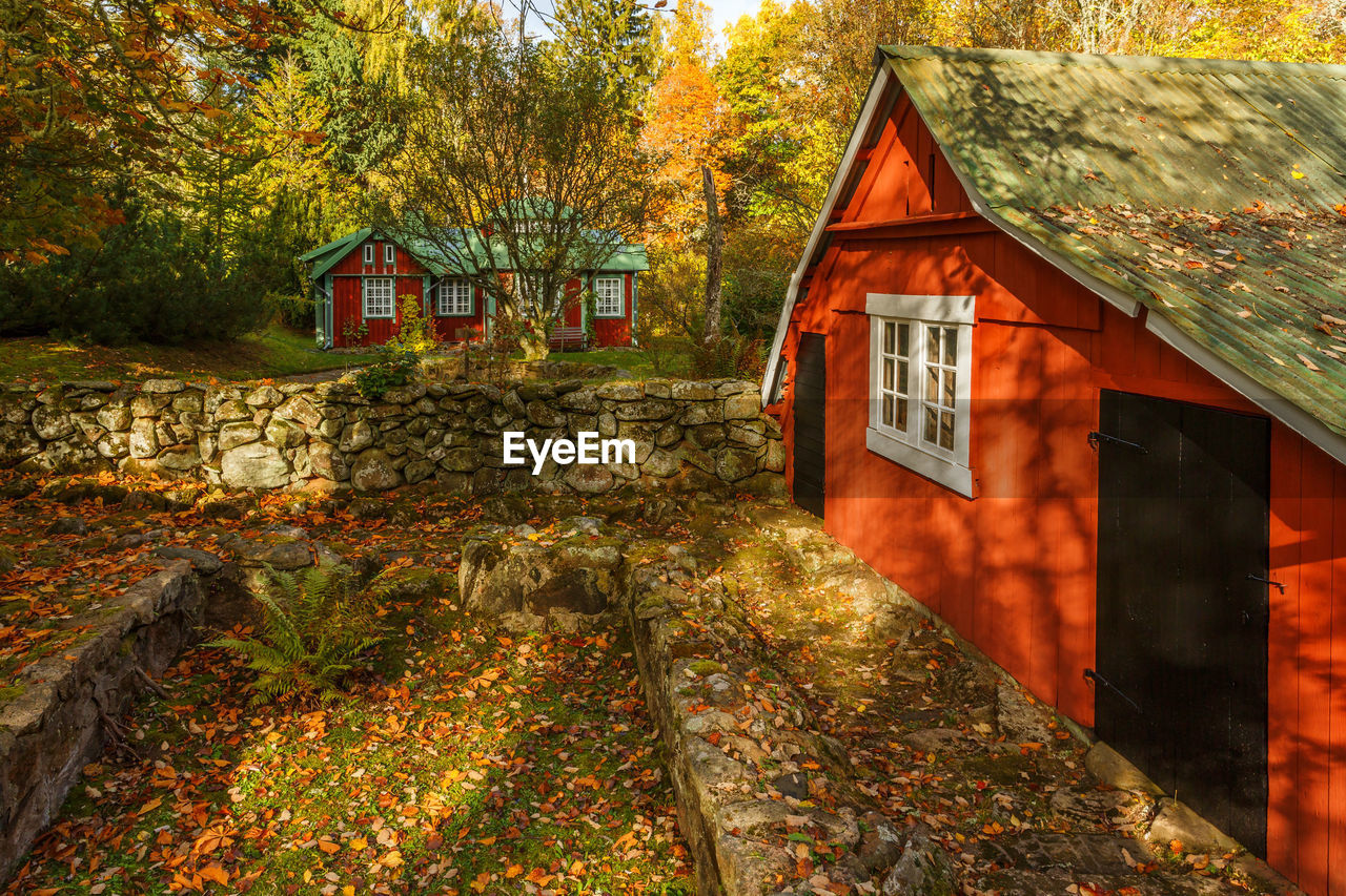 Cottage in a garden with a garden shed with autumn colors