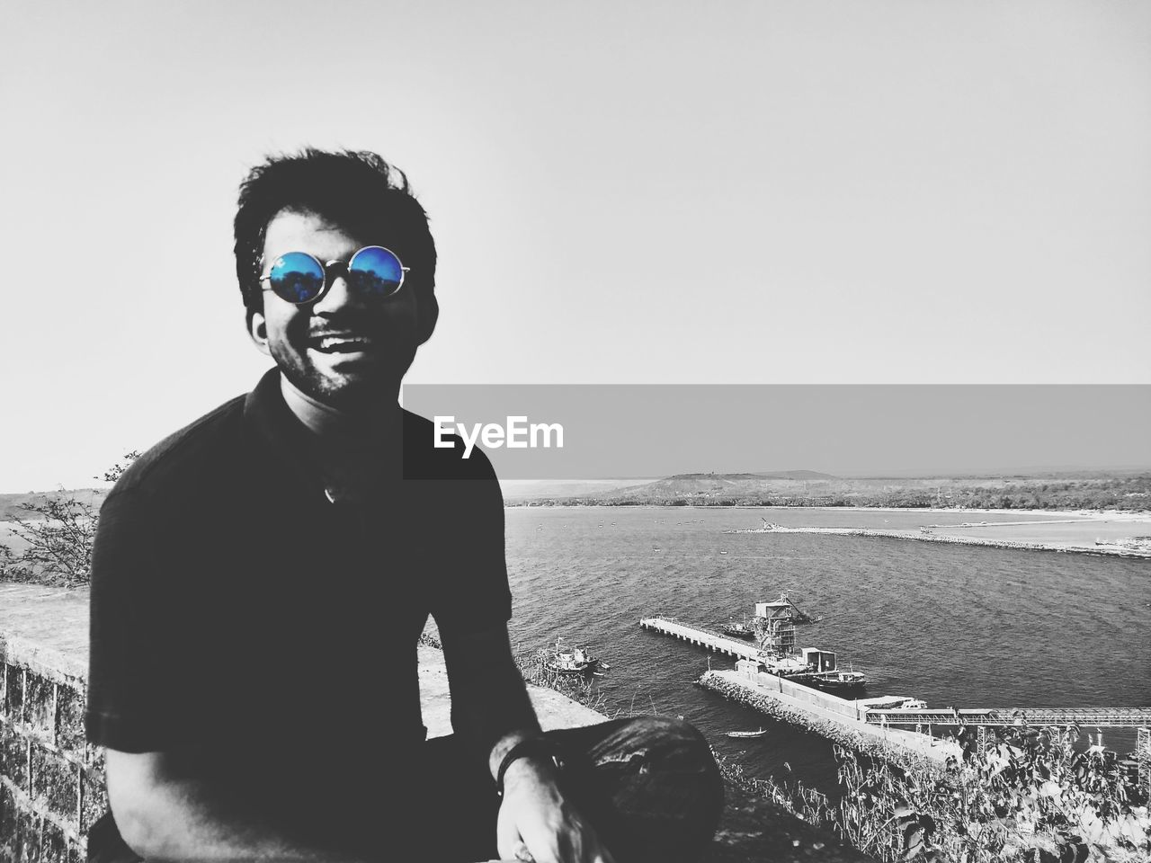 PORTRAIT OF YOUNG MAN STANDING IN SEA AGAINST CLEAR SKY