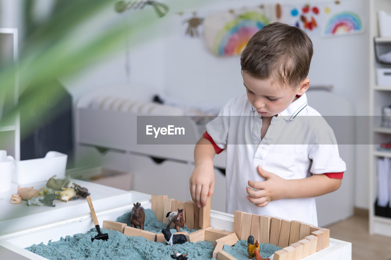 side view of boy playing with toys on table