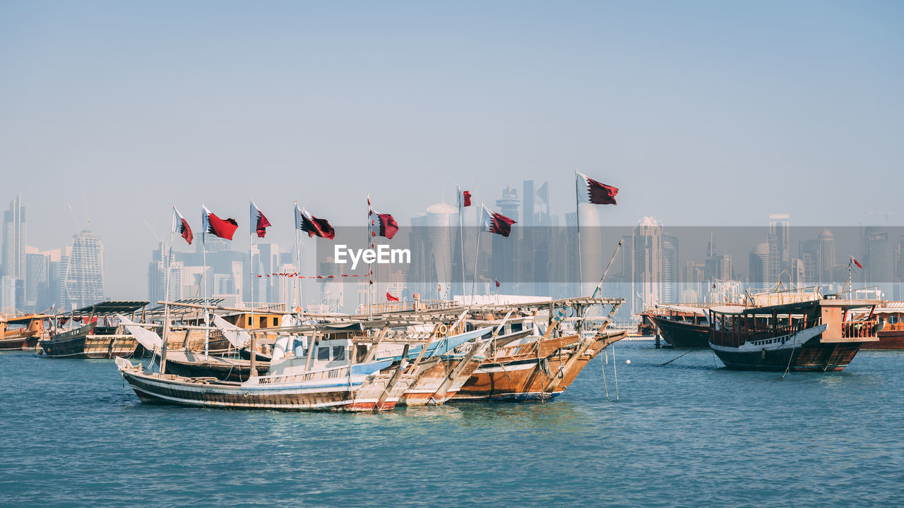 Boats on sea against buildings in city