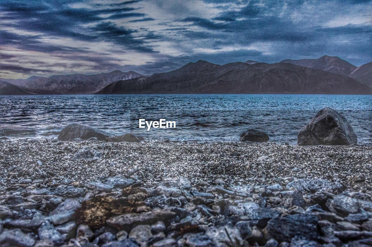 SCENIC VIEW OF LAKE BY MOUNTAINS AGAINST SKY