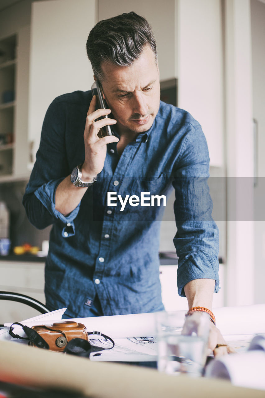 Man in office at home talking in telephone