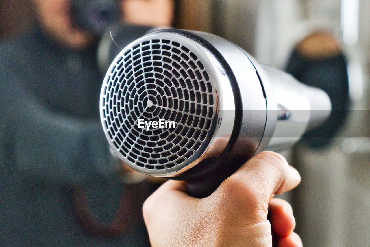 Close-up of person holding hair dryer