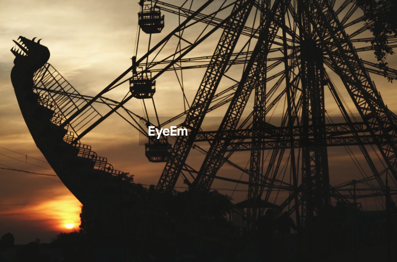 LOW ANGLE VIEW OF FERRIS WHEEL AT SUNSET