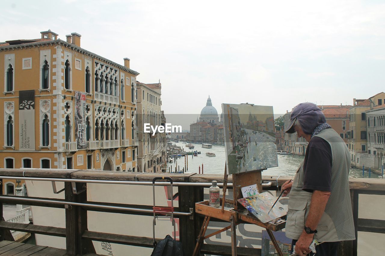 MAN STANDING BY RAILING IN CITY