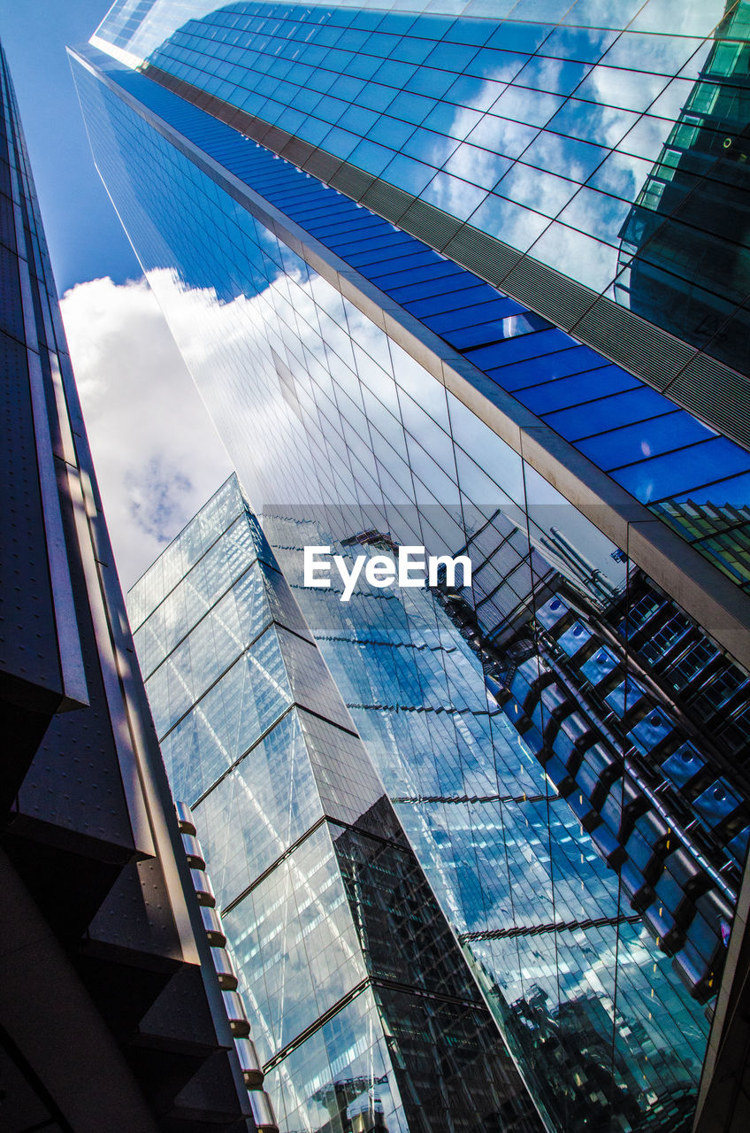 Low angle view of modern glass building against sky