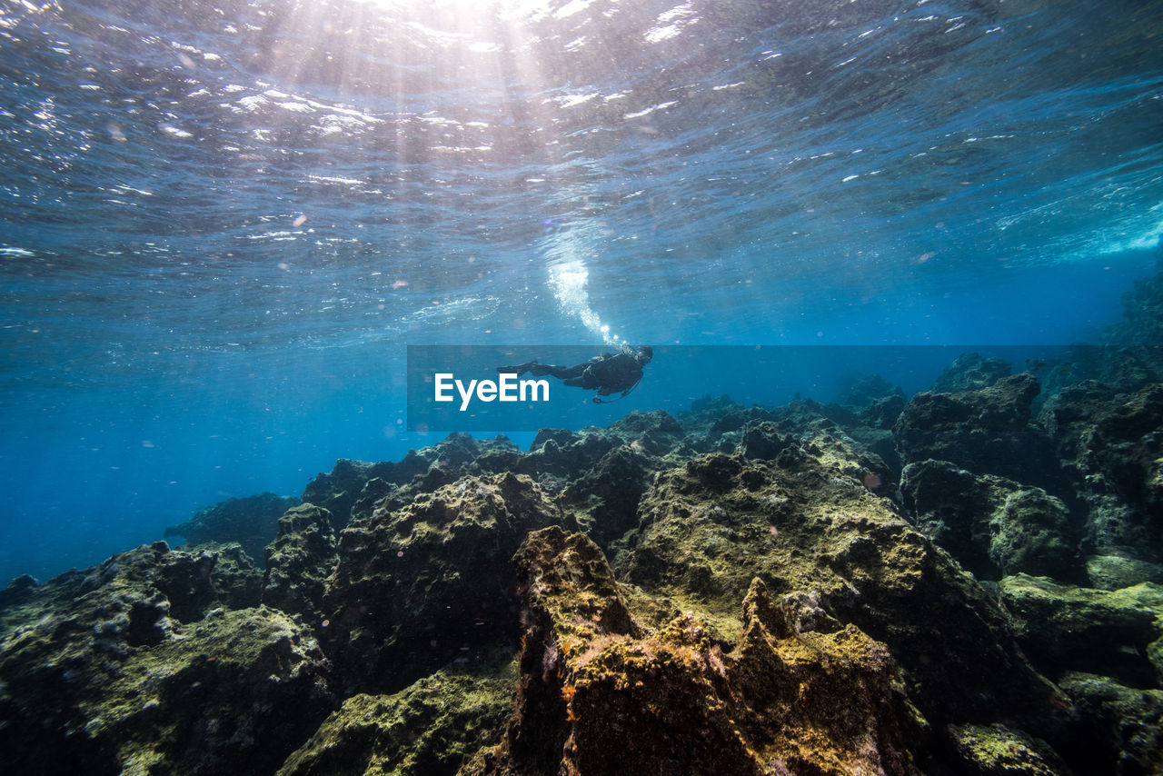 Person in sea against blue sky