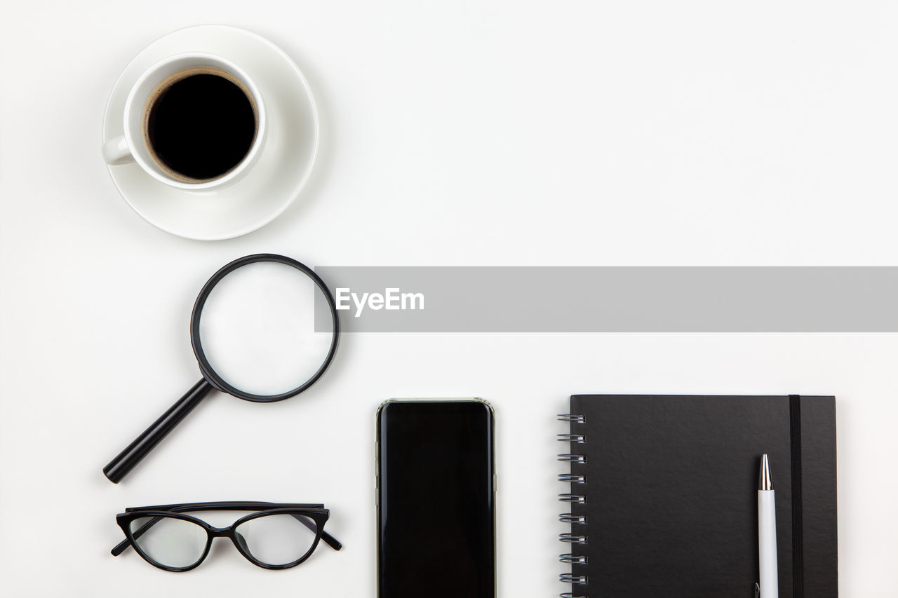 DIRECTLY ABOVE SHOT OF COFFEE CUP ON TABLE AGAINST WHITE BACKGROUND