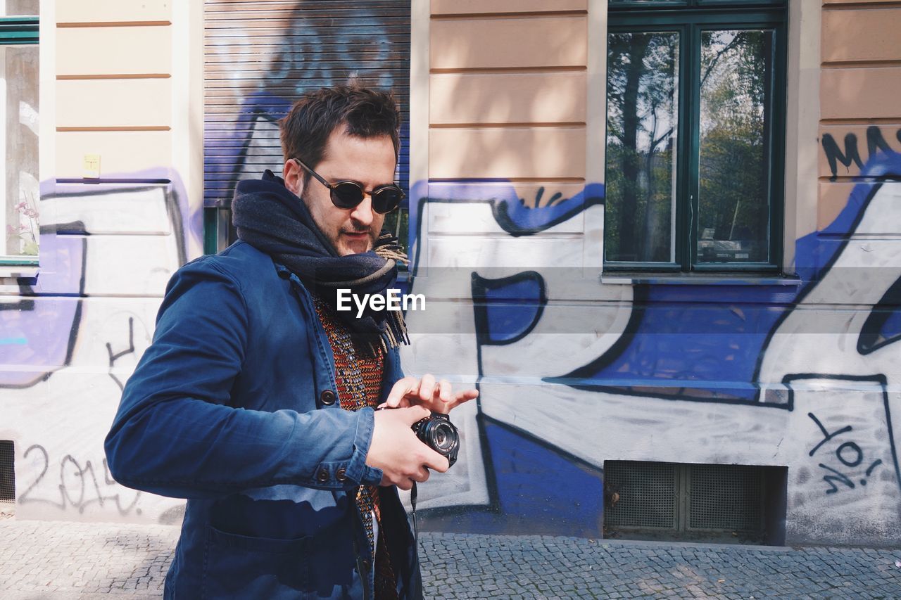 FULL LENGTH OF YOUNG MAN WEARING SUNGLASSES