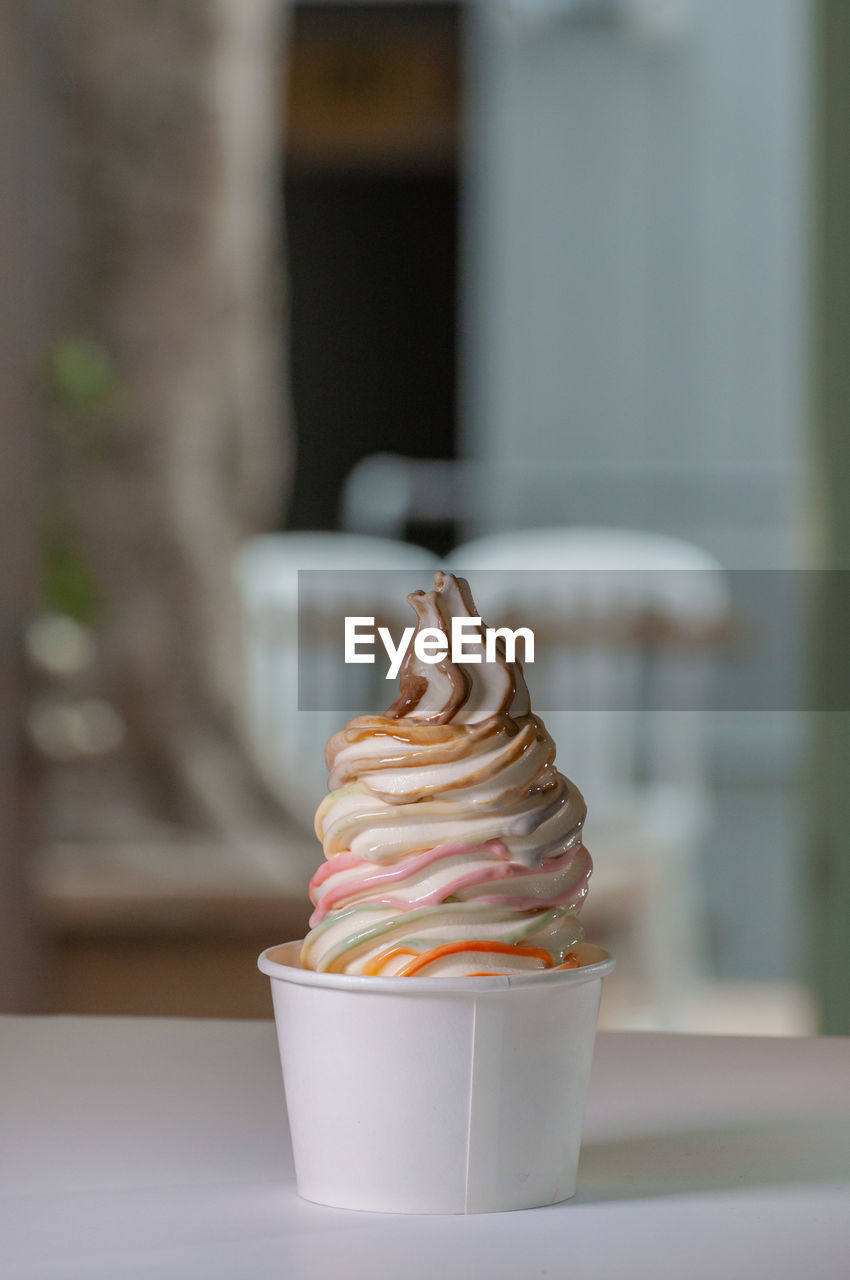 CLOSE-UP OF ICE CREAM ON GLASS TABLE