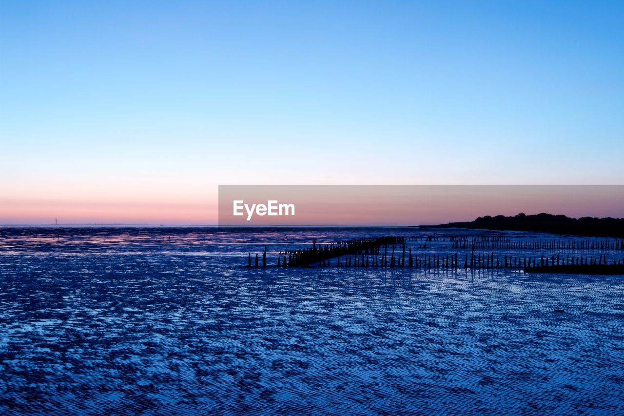 Scenic view of sea against clear sky at sunset