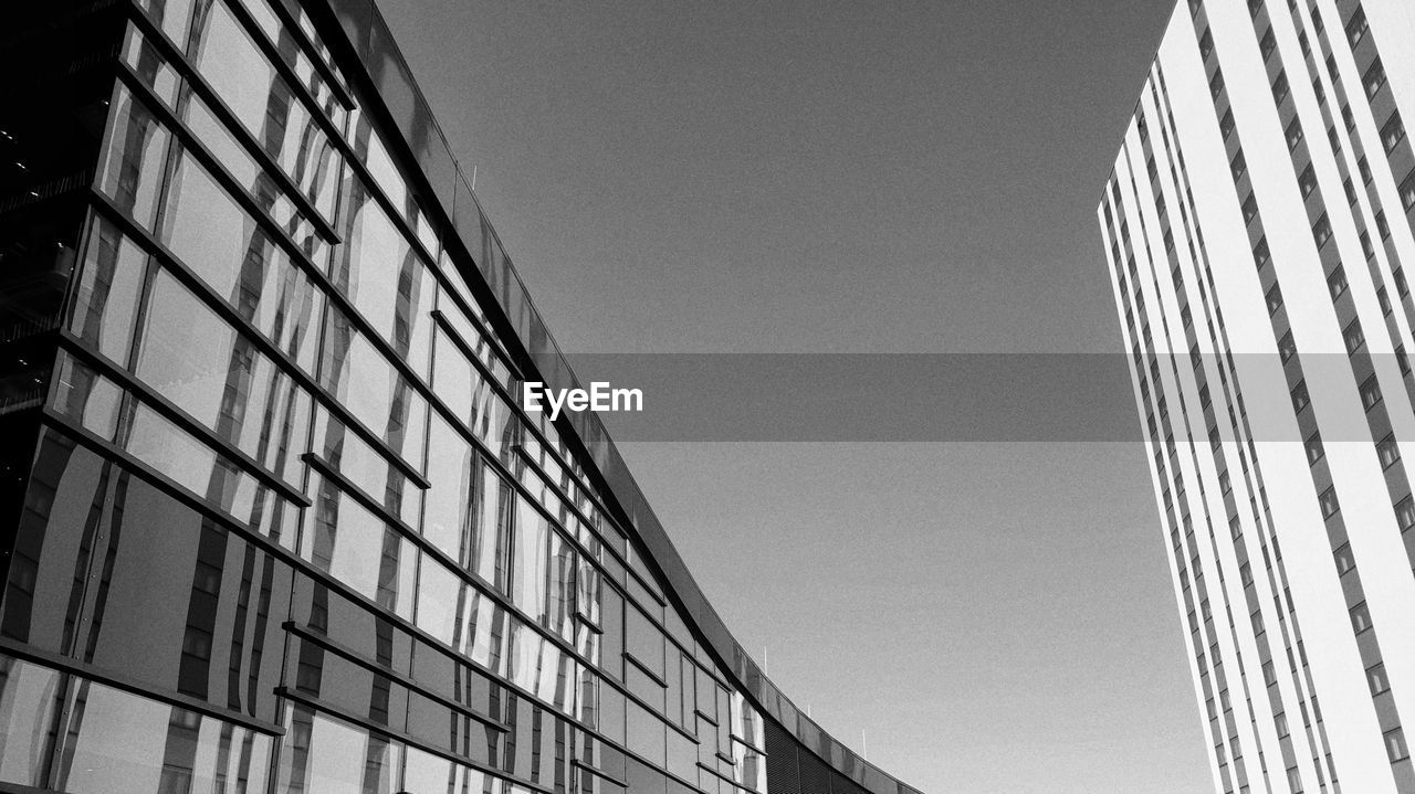 LOW ANGLE VIEW OF GLASS BUILDING AGAINST CLEAR SKY