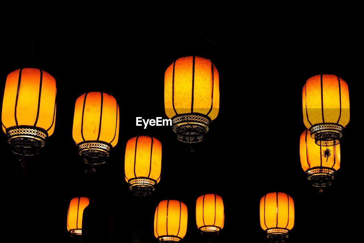 LOW ANGLE VIEW OF ILLUMINATED LANTERNS HANGING AGAINST SKY