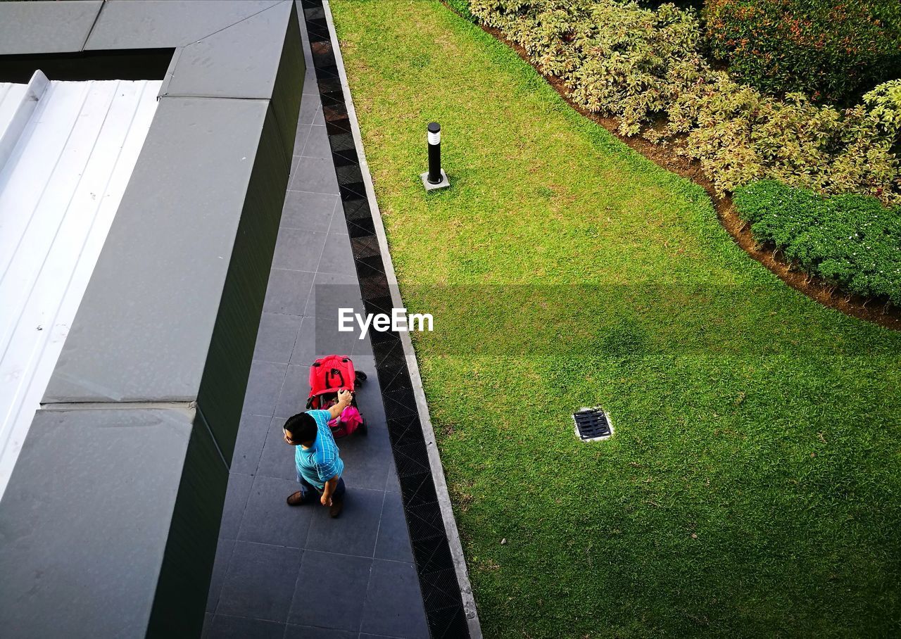 High angle view of man with luggage standing by field