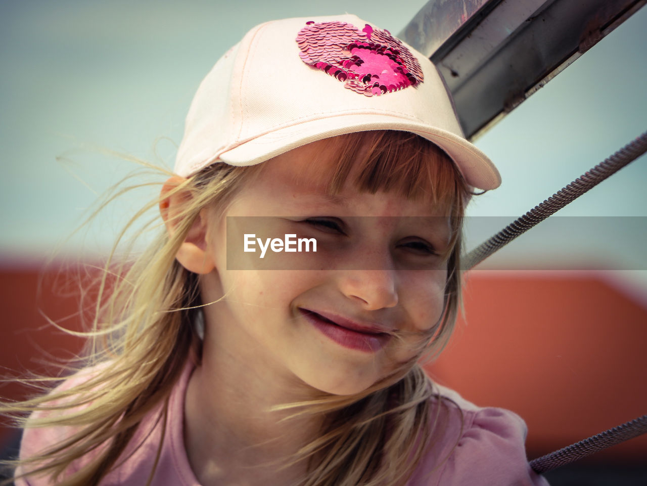 Close-up portrait of smiling girl wearing cap