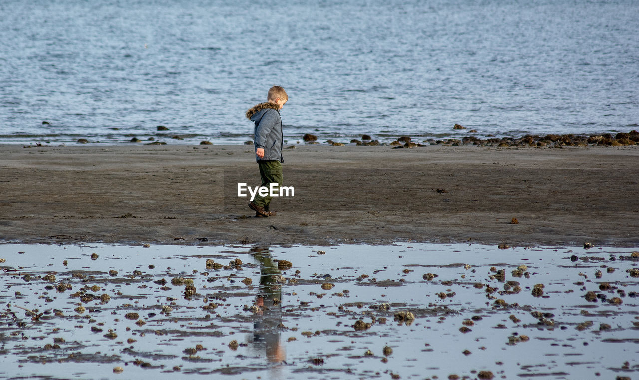 Side view of boy walking at beach