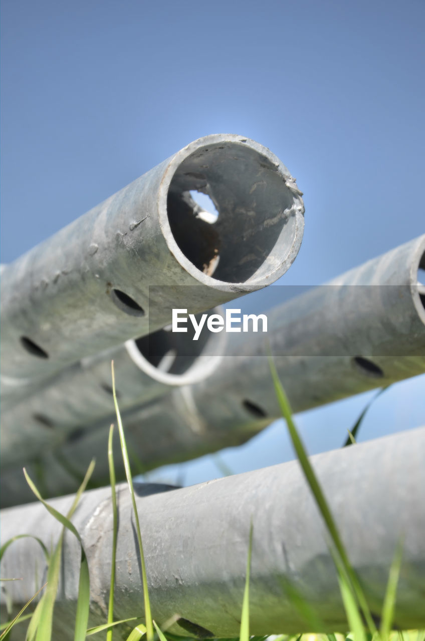 CLOSE-UP OF HOLE ON FIELD AGAINST SKY