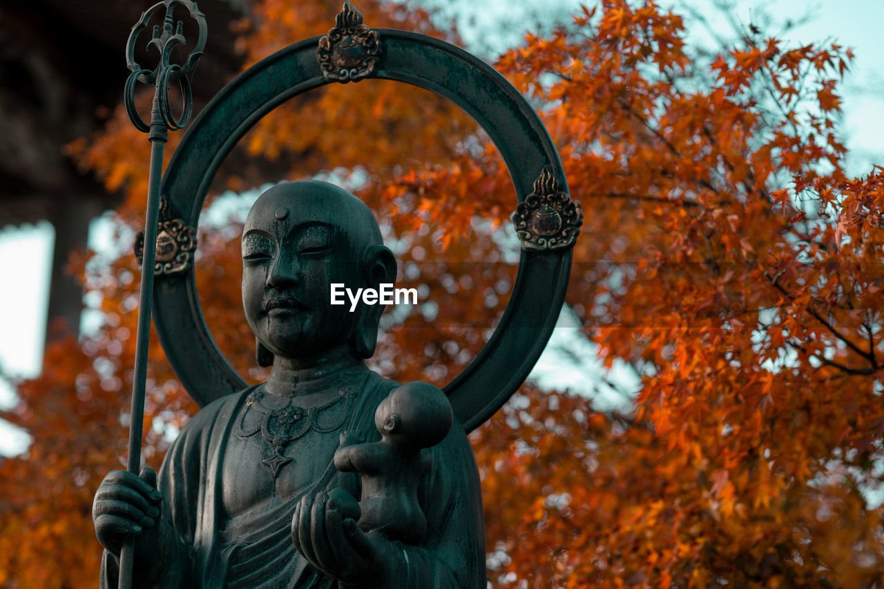 Close-up of statue against trees during autumn