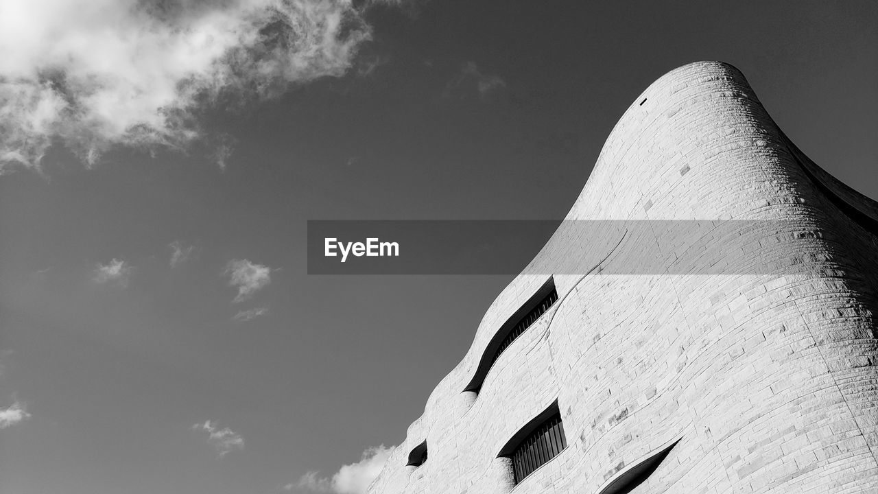 Low angle view of building against cloudy sky