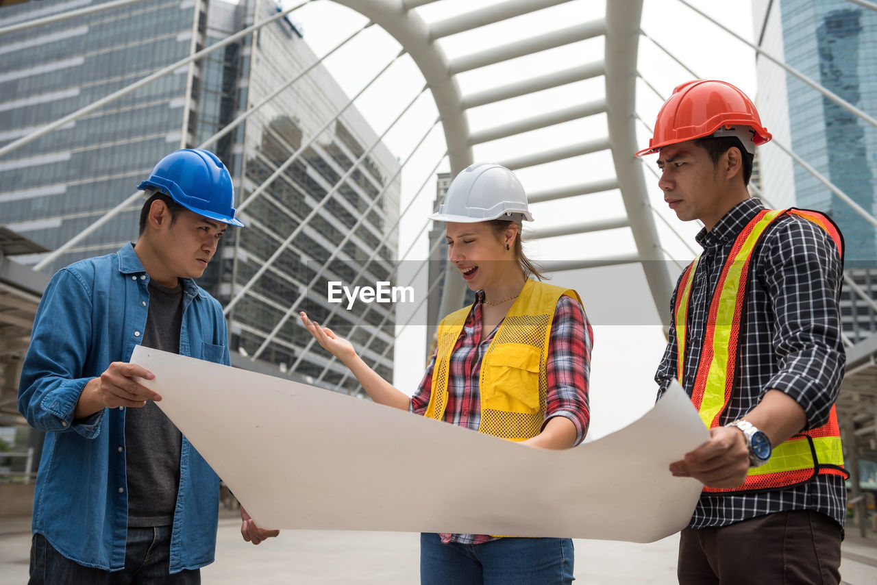 Engineers discussing over blueprint at construction site
