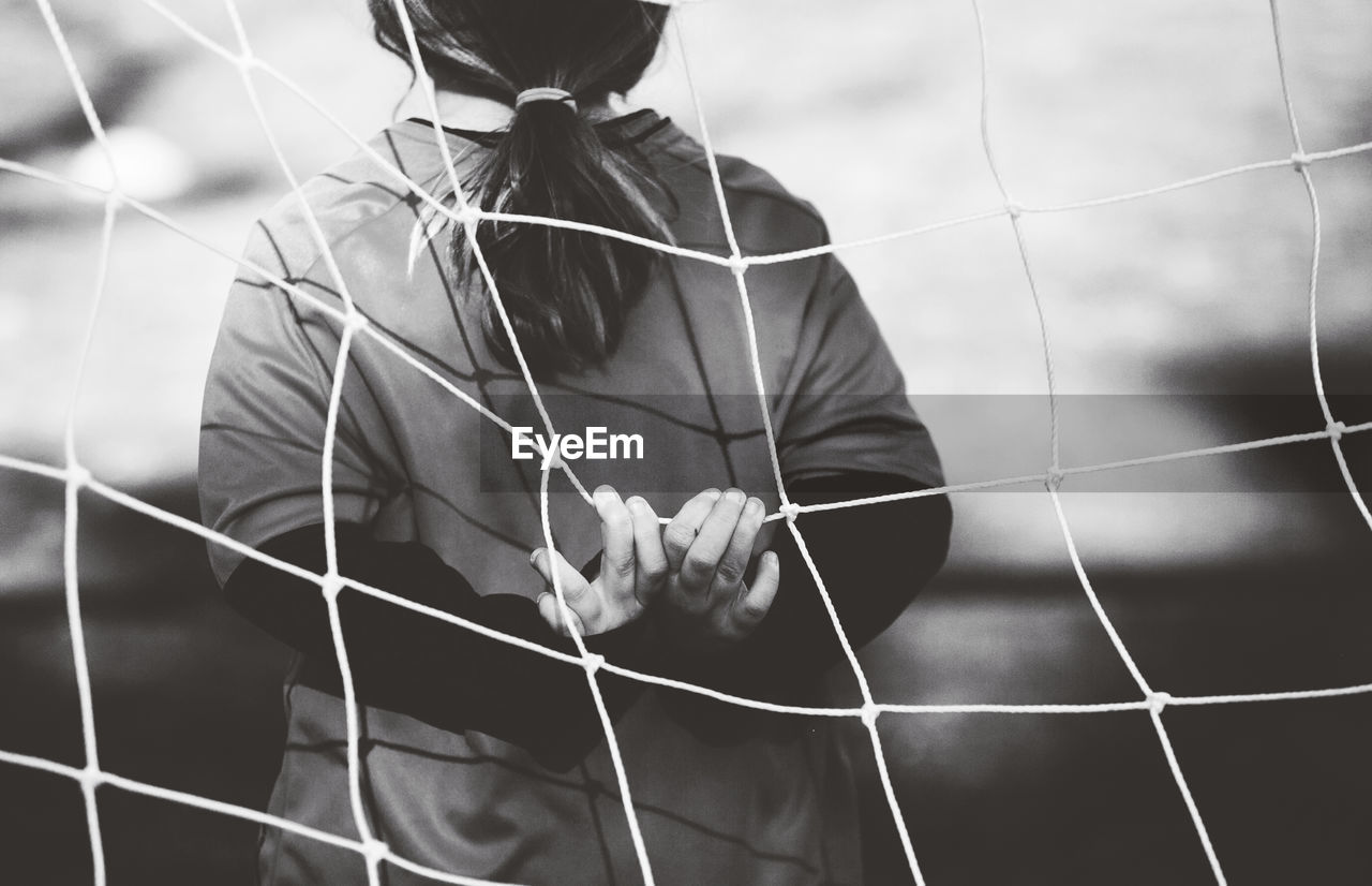 Rear view of child in soccer goal