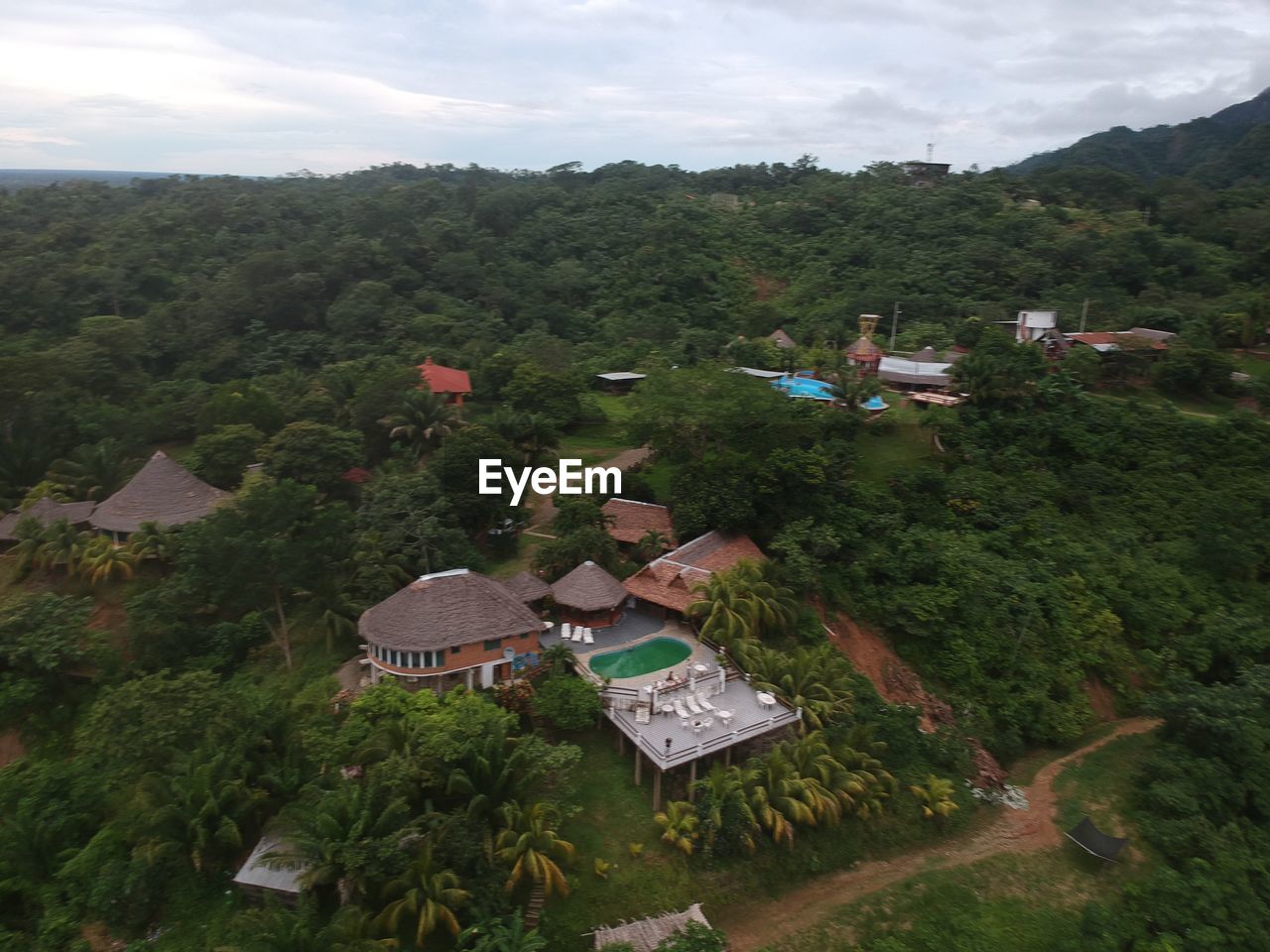 HIGH ANGLE VIEW OF HOUSES BY TREES AGAINST SKY