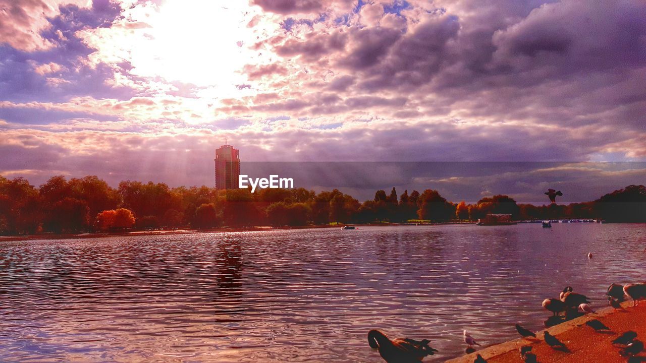 VIEW OF RIVER AGAINST CLOUDY SKY AT SUNSET