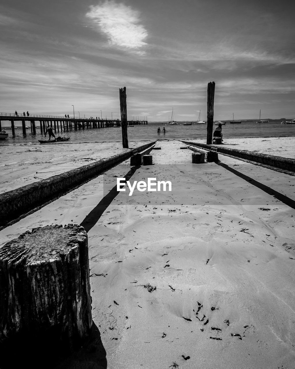 SCENIC VIEW OF WOODEN POSTS ON BEACH