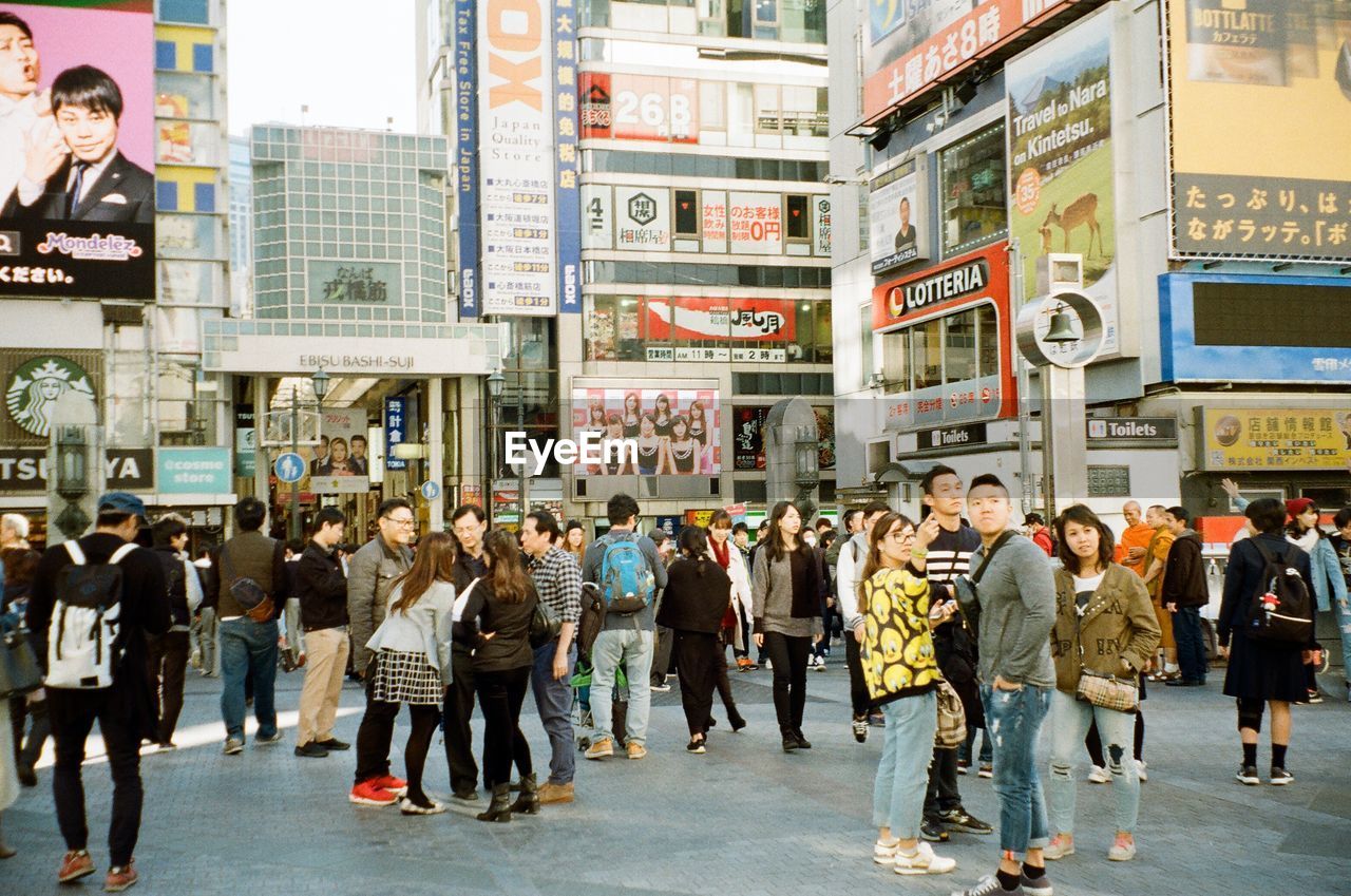 PEOPLE WALKING ON ROAD IN CITY