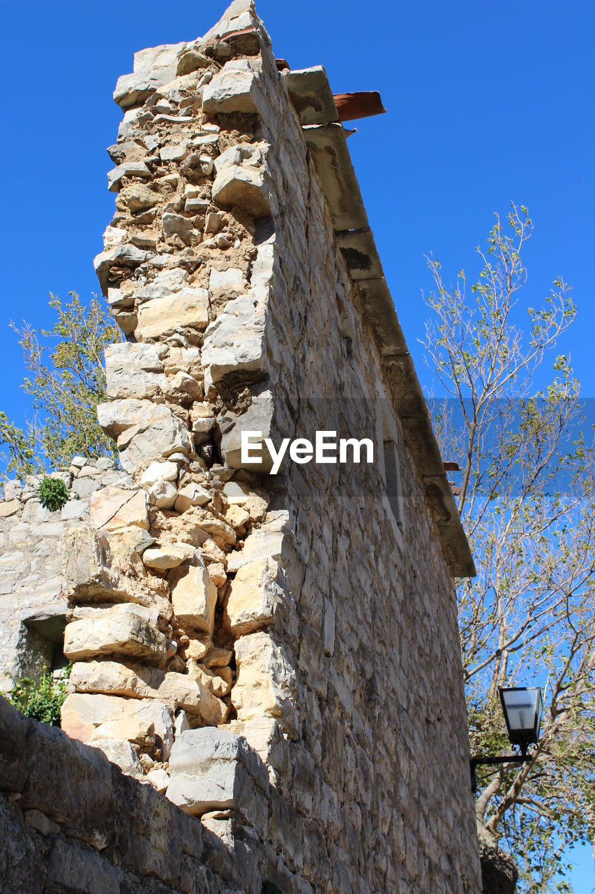 LOW ANGLE VIEW OF BUILT STRUCTURE AGAINST CLEAR BLUE SKY