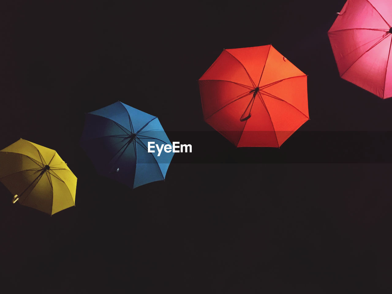 Low angle view of umbrella against black background