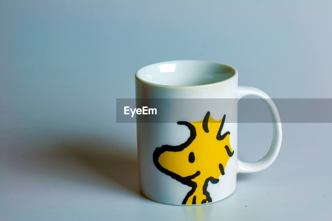 mug, cup, coffee cup, studio shot, drinkware, drink, indoors, ceramic, food and drink, no people, yellow, colored background, blue, animal, refreshment, tableware, single object, animal themes, animal representation, representation, copy space