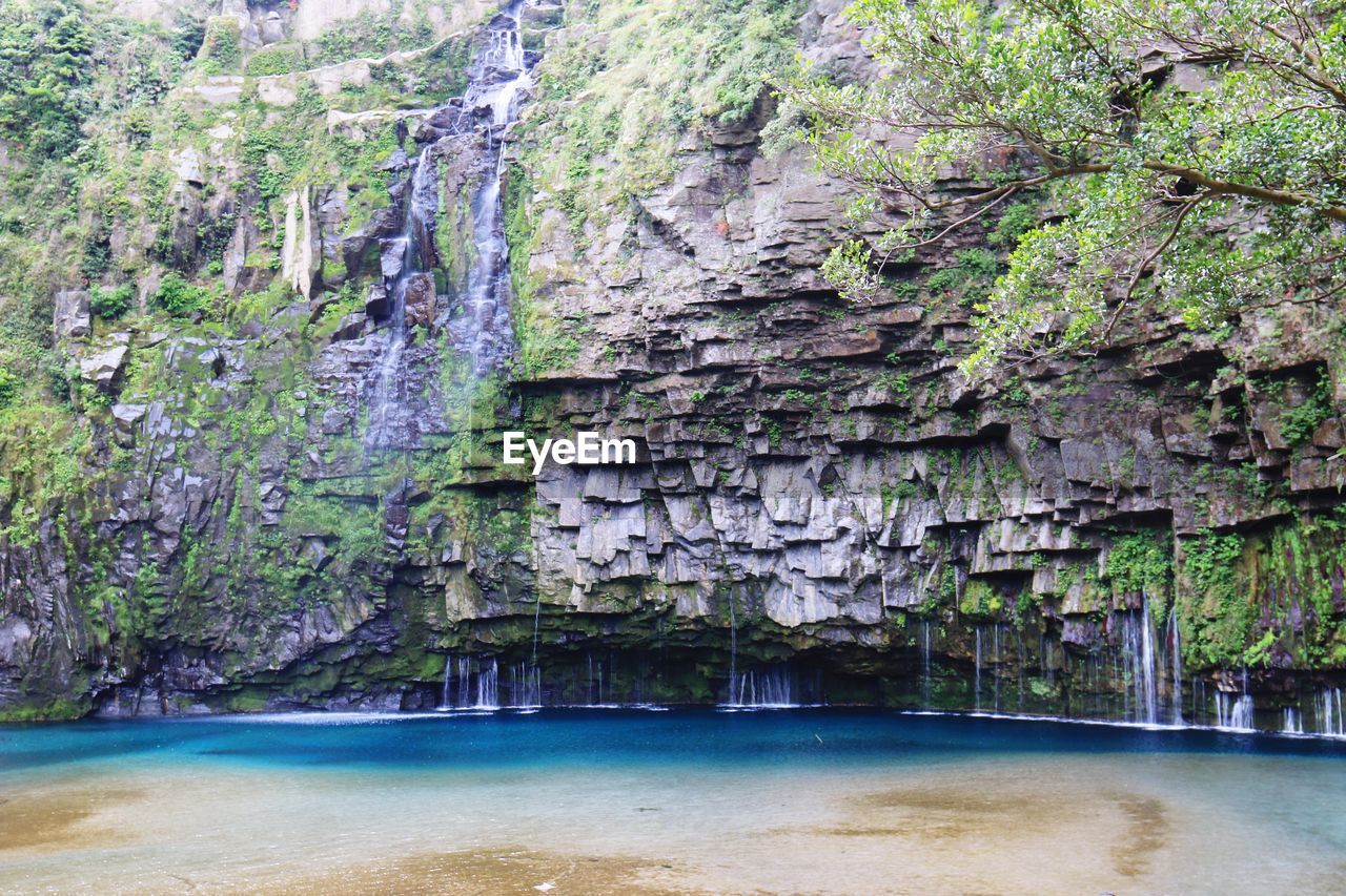 Scenic view of waterfall against rock formation