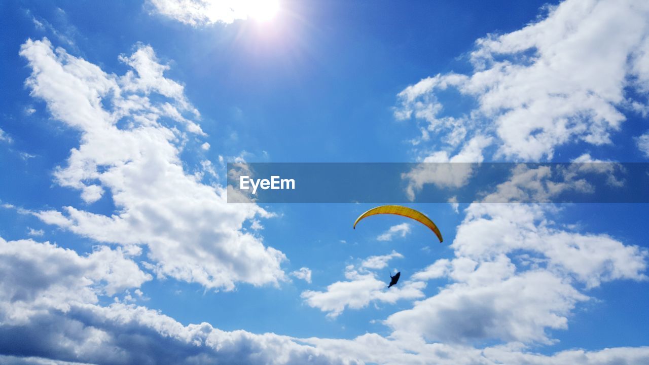 Low angle view of person parachuting against sky