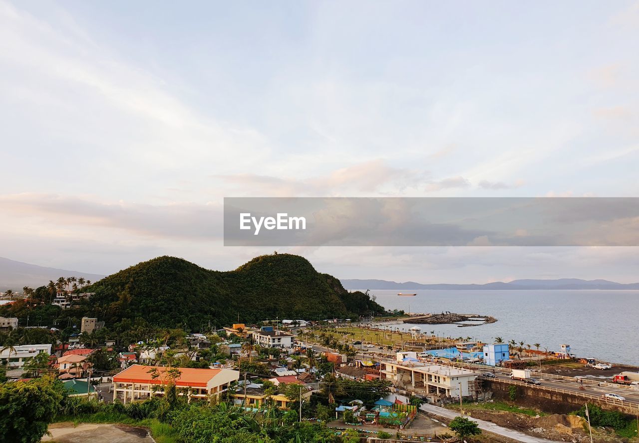 High angle view of townscape by sea against sky