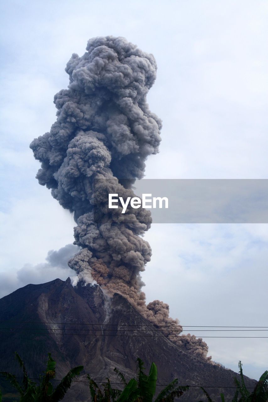 Low angle view of mountain against cloudy sky