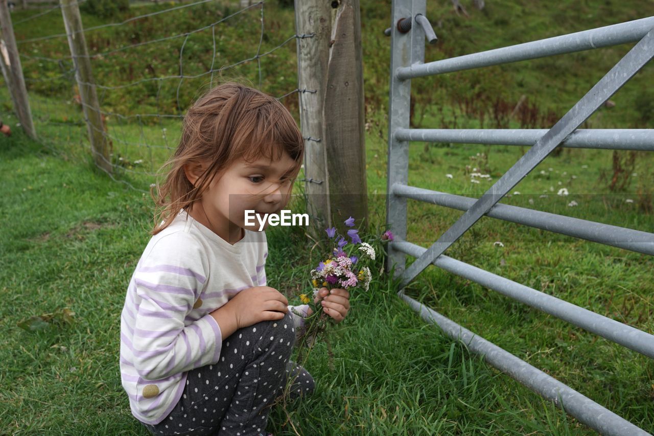 Full length of girl holding flowering plants