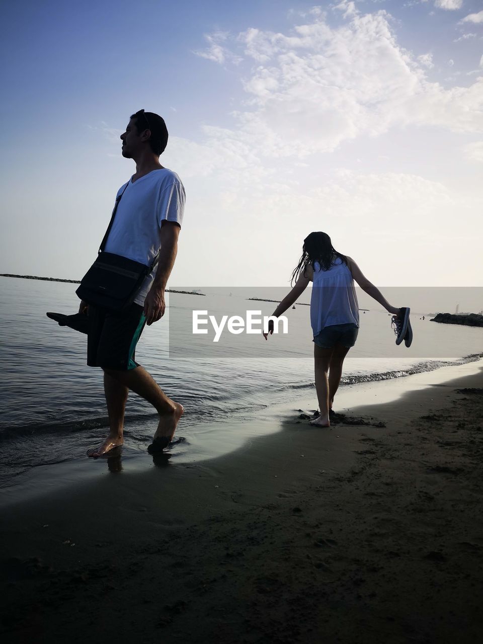 Rear view of people walking on beach