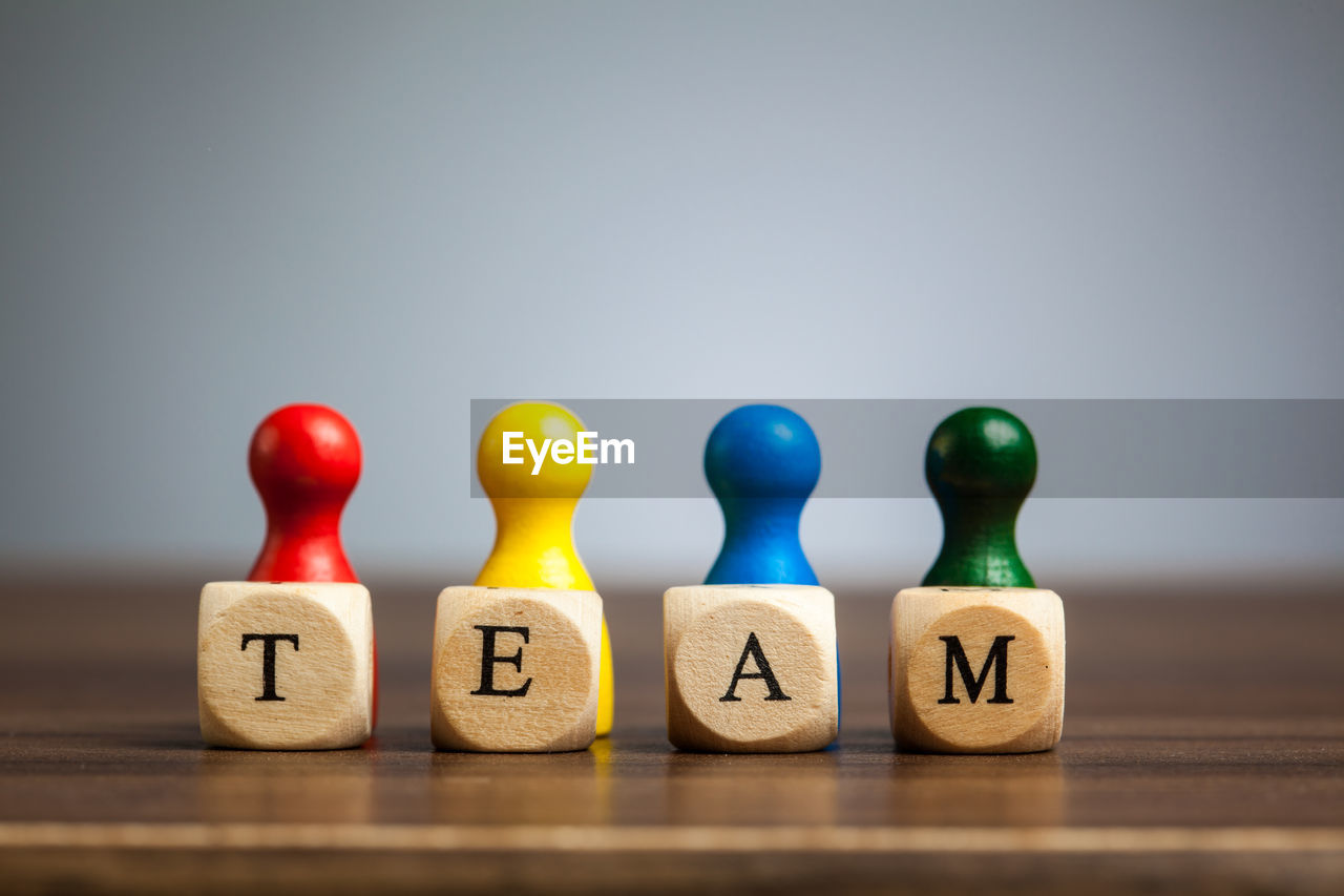 Close-up of tokens with team text on table against gray background