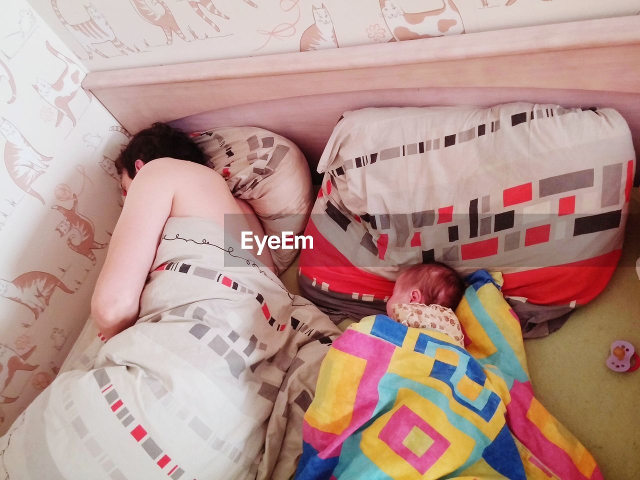 High angle view of father with daughter sleeping on bed at home