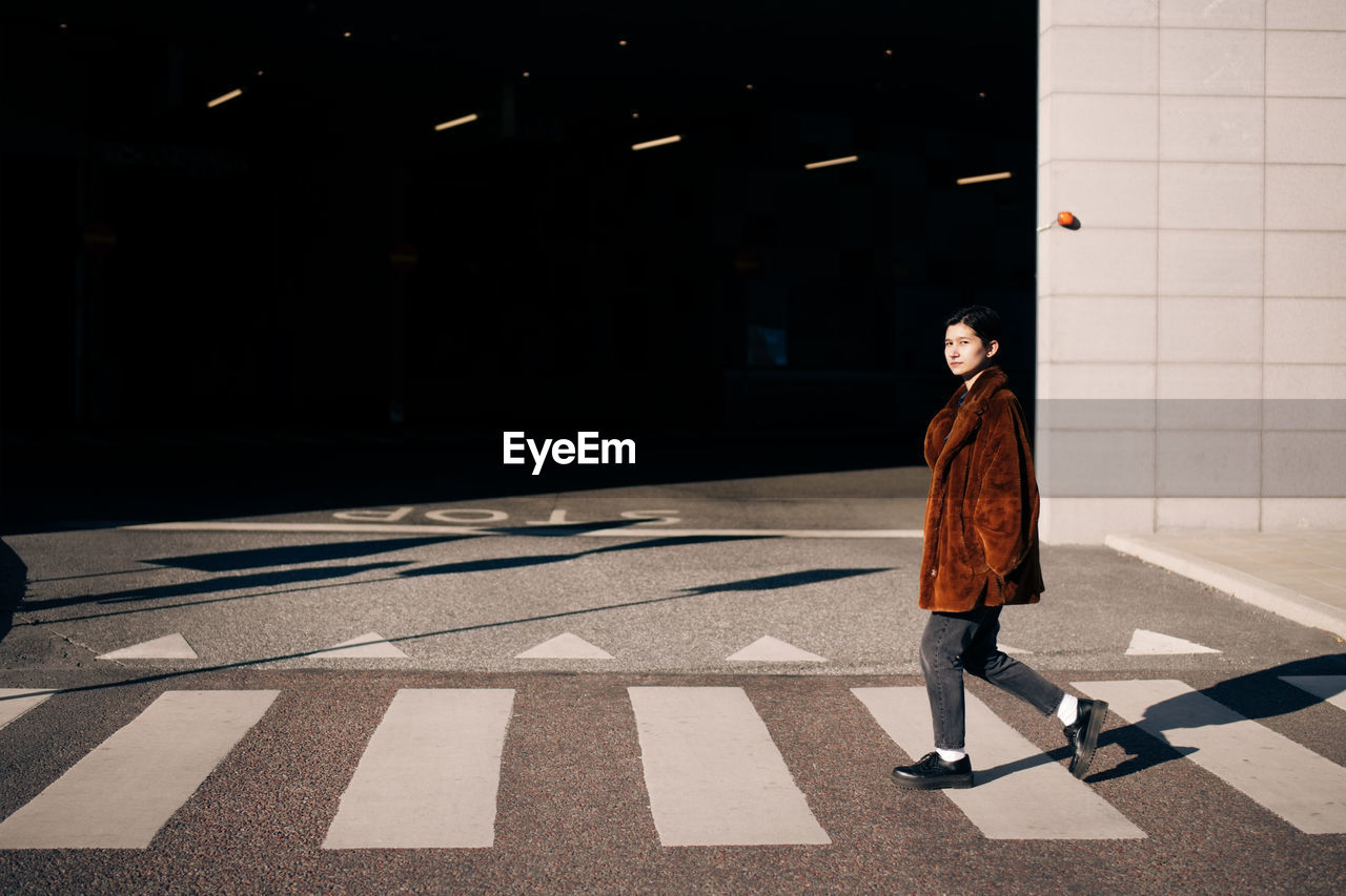 Portrait of woman crossing road