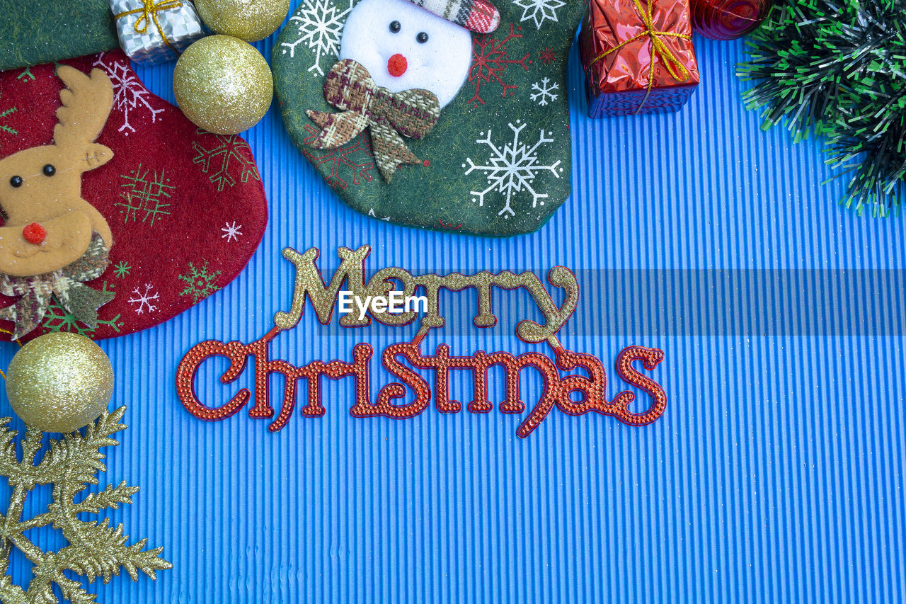holiday, celebration, christmas, christmas tree, christmas decoration, decoration, text, christmas ornament, tradition, no people, indoors, western script, still life, event, tree, representation, high angle view, blue, communication, gift, table, multi colored, food, snowman, creativity, animal representation, winter, cookie, food and drink, close-up, pattern, star shape, craft