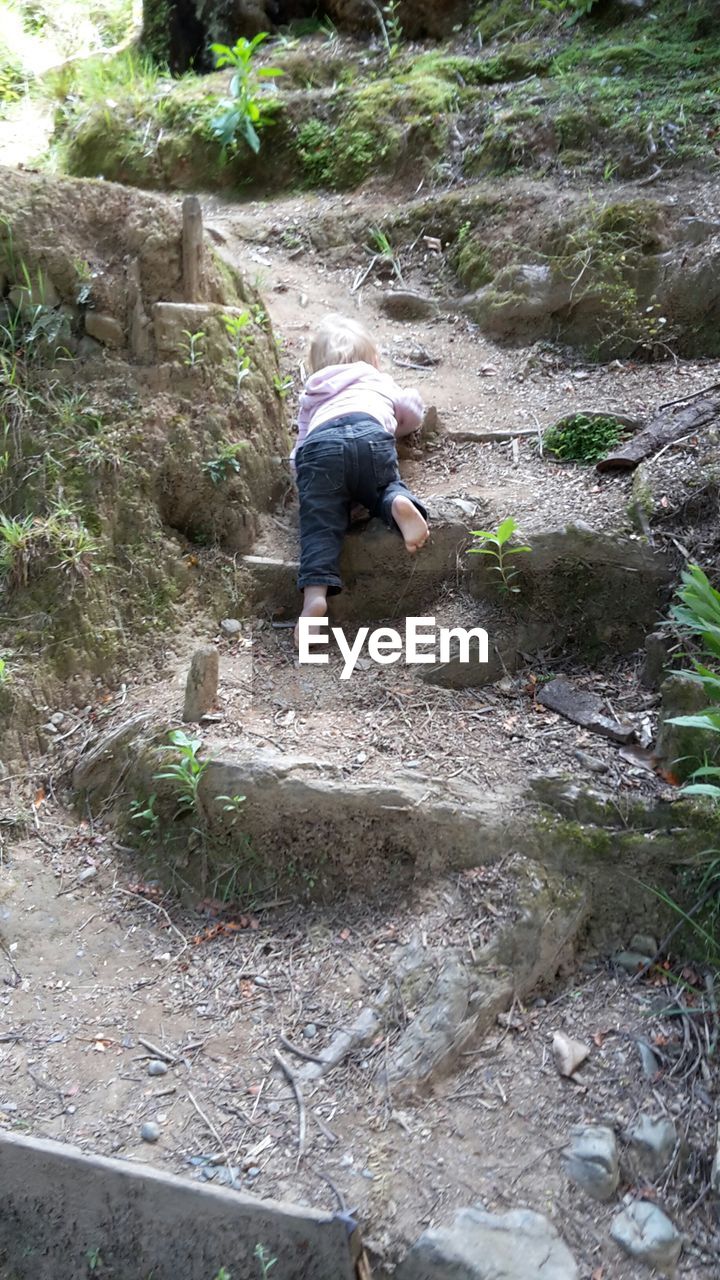 YOUNG WOMAN JUMPING ON ROCK