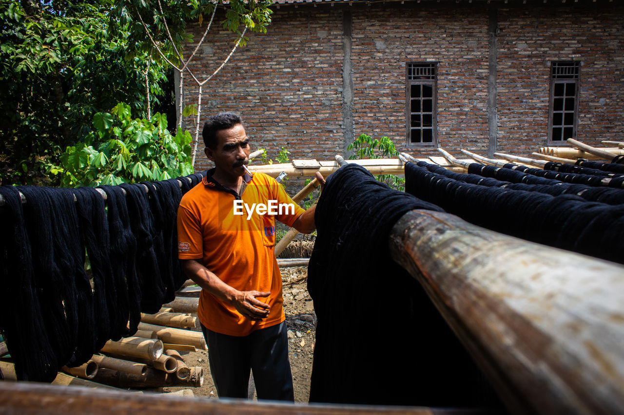  the craftsmen do  dyeing process of the fabric lurik in tringsing village,  java, indonesia