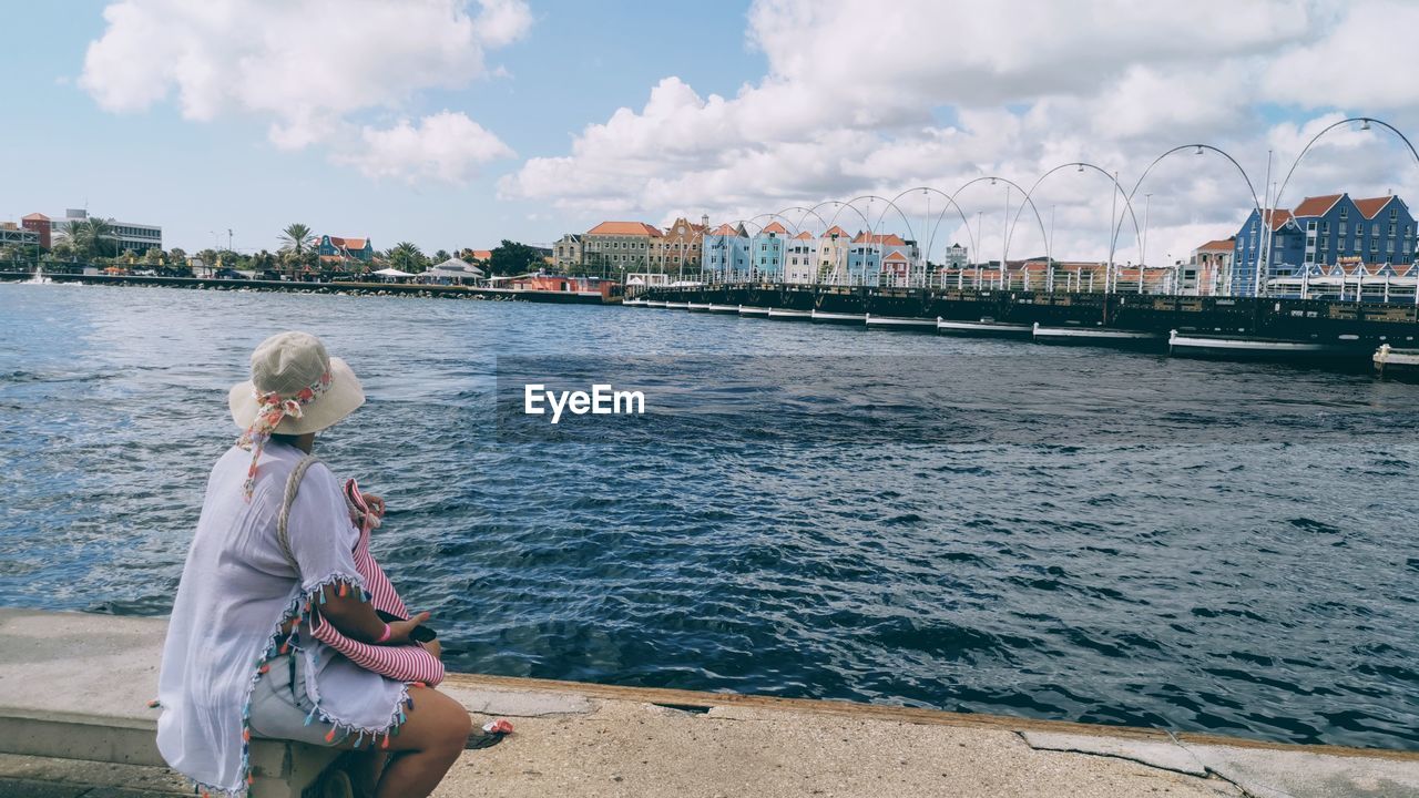 Woman looking at sea against sky