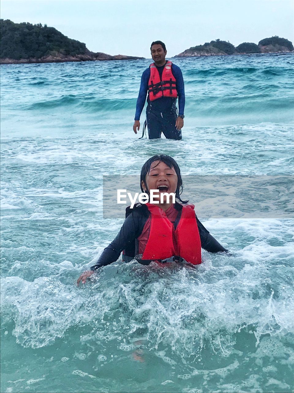 Father and son swimming in sea