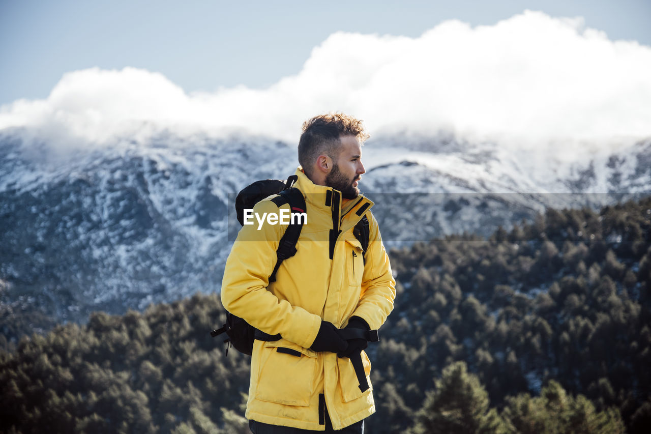 Young man with yellow jacket and backpack in the mountains.