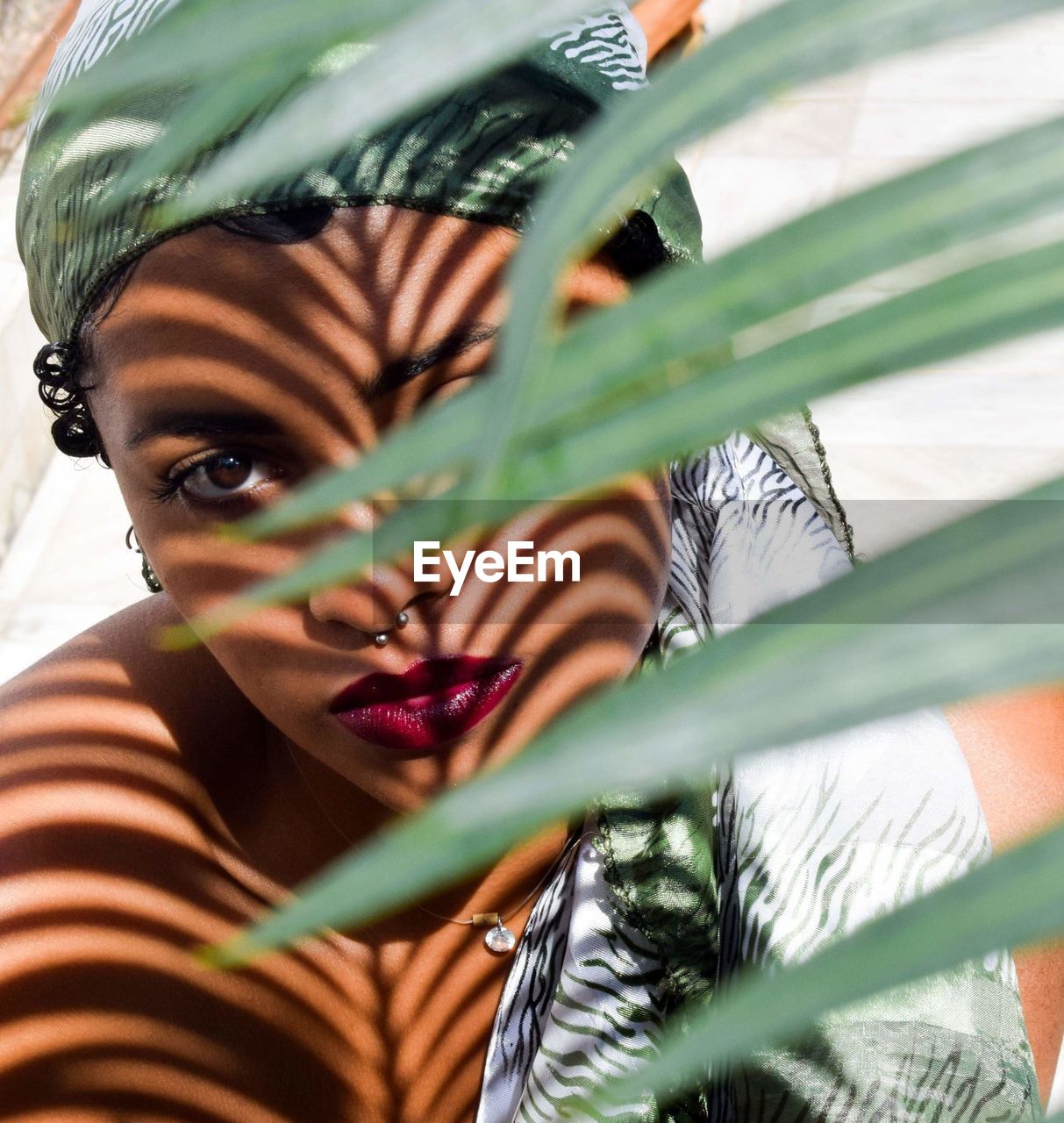 Portrait of woman wearing lipstick by plants