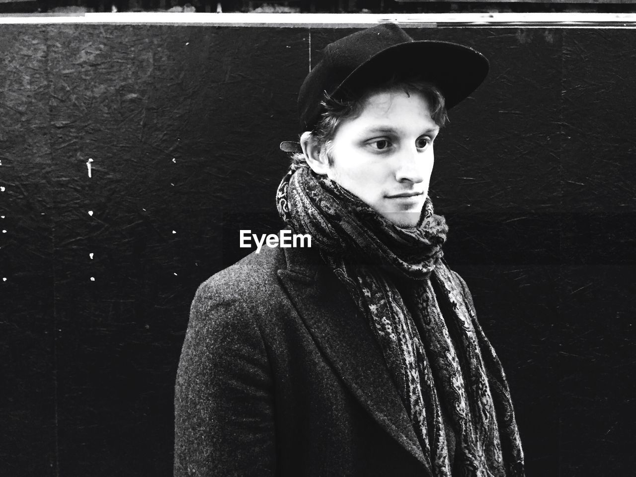 Young man wearing cap looking away