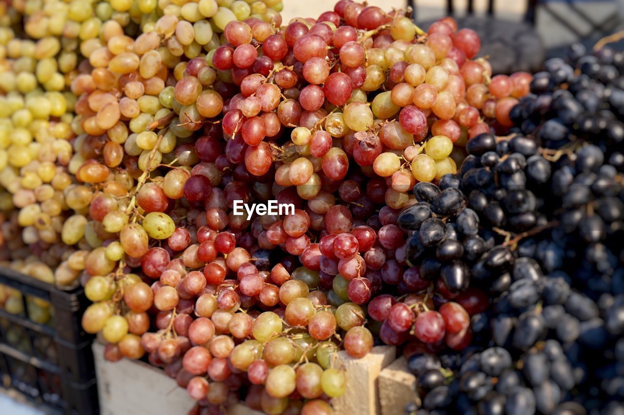 HIGH ANGLE VIEW OF GRAPES FOR SALE AT MARKET STALL